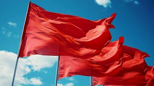 红色警示旗飘扬于蓝天白云间