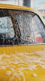 黄色汽车正在泡沫洗车