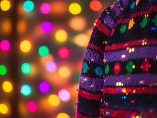 节日彩灯旁的多彩针织衫