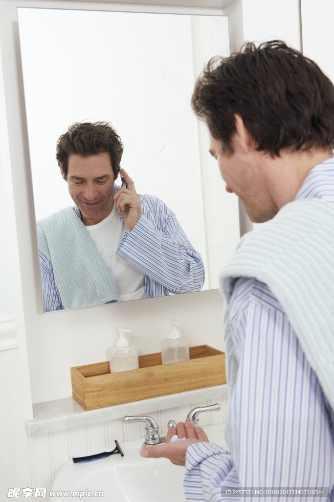 边接电话边刮胡子的男士