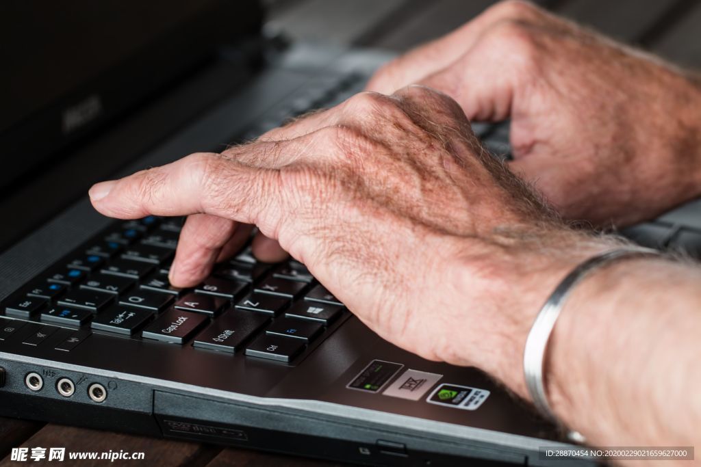手打字笔记本电脑工作的老人