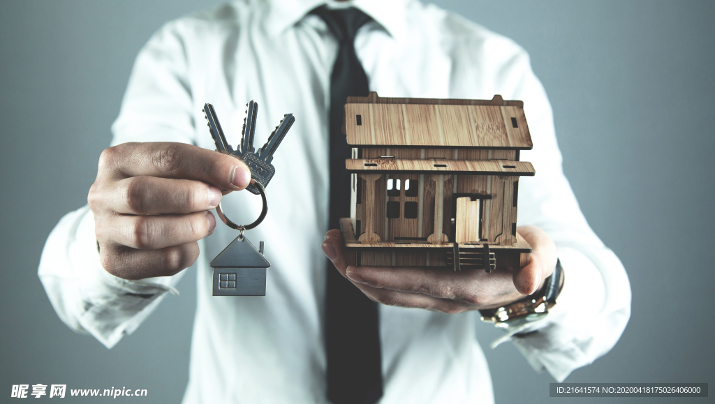 手中的钥匙与房屋模型特写