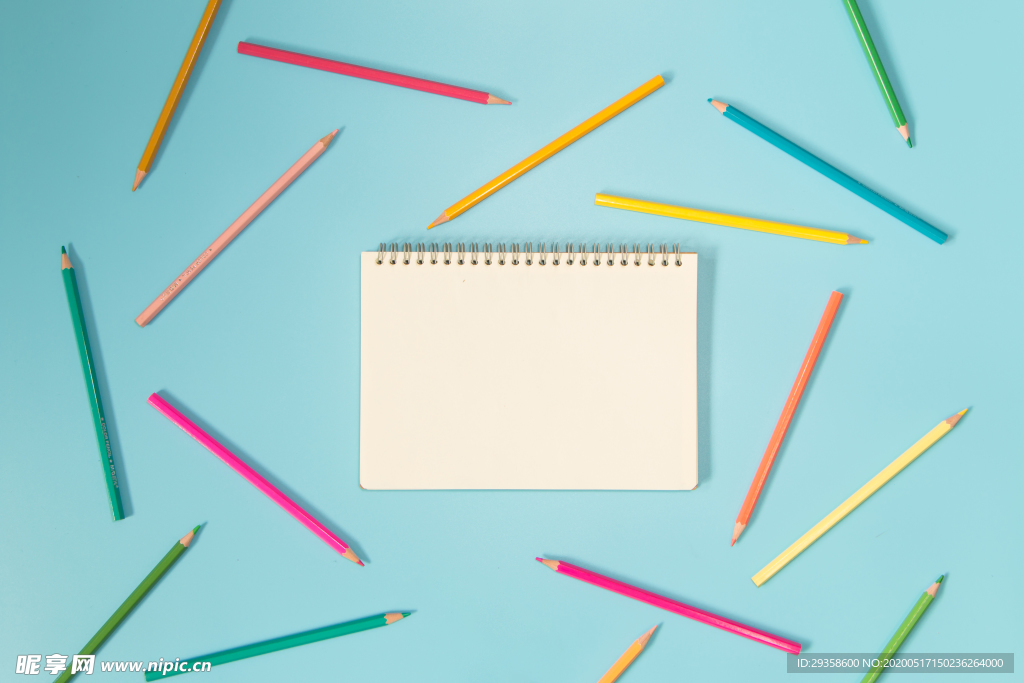 蓝色背景下的笔记本和笔