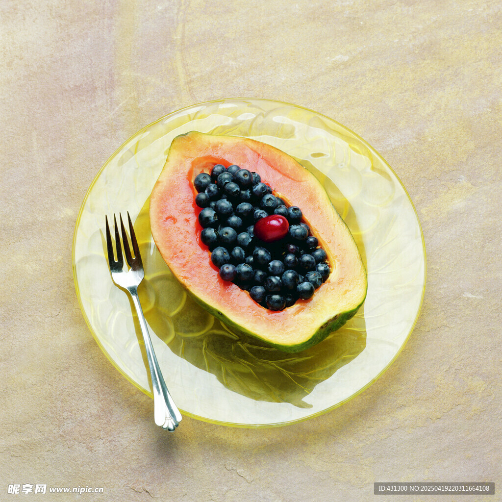 切开的木瓜配蓝莓和叉子