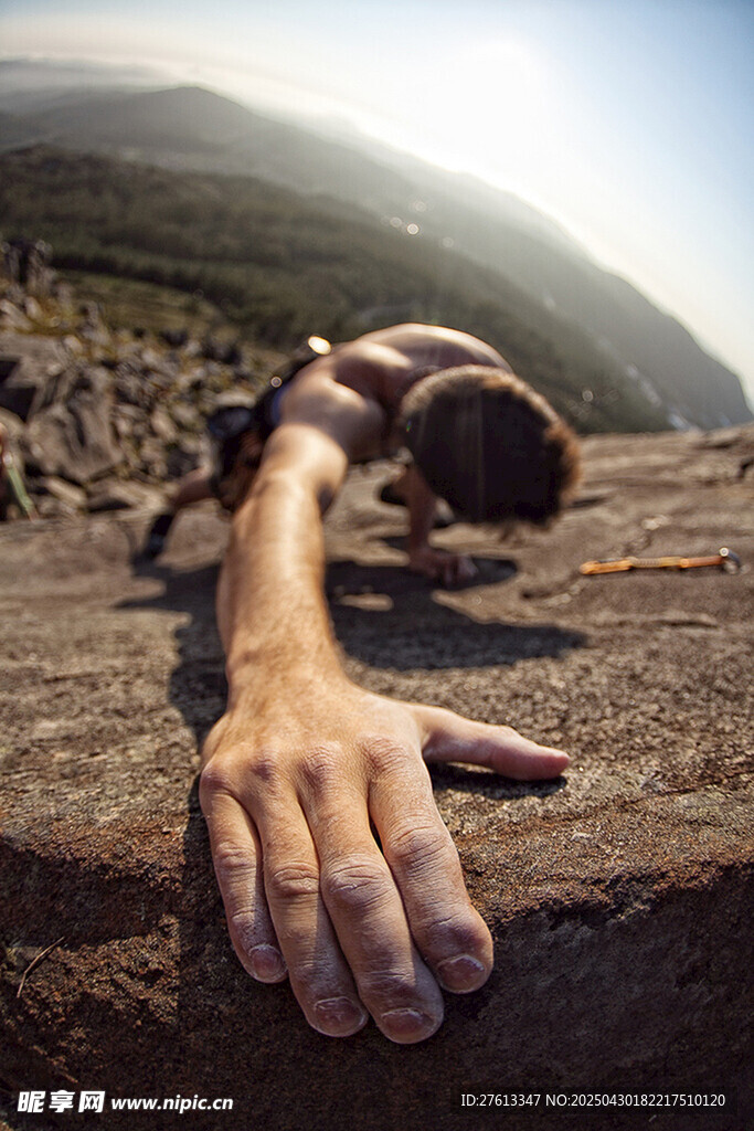 伸手攀登攀岩的户外遇险者
