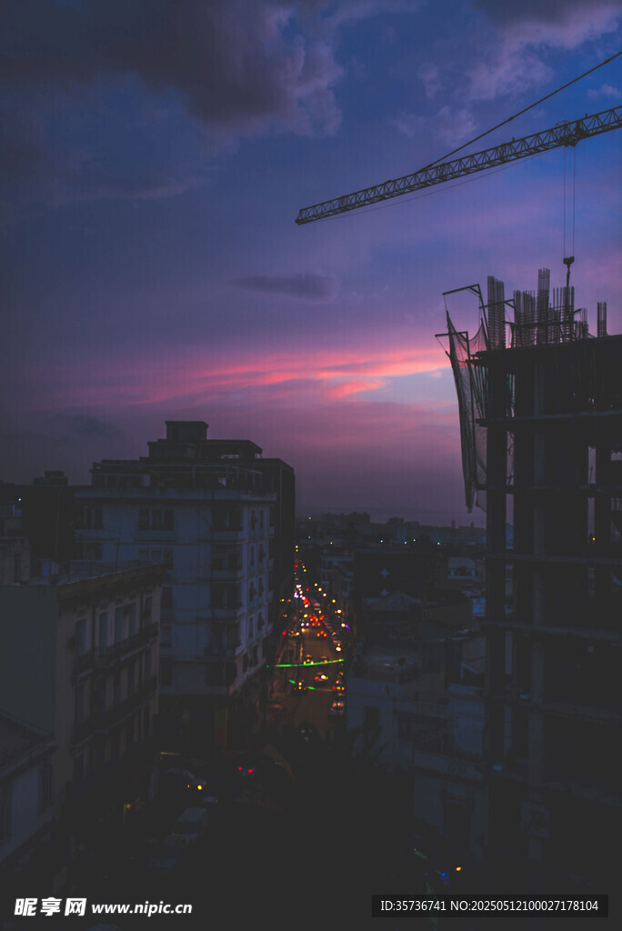 城市暮色中的建筑与起重机