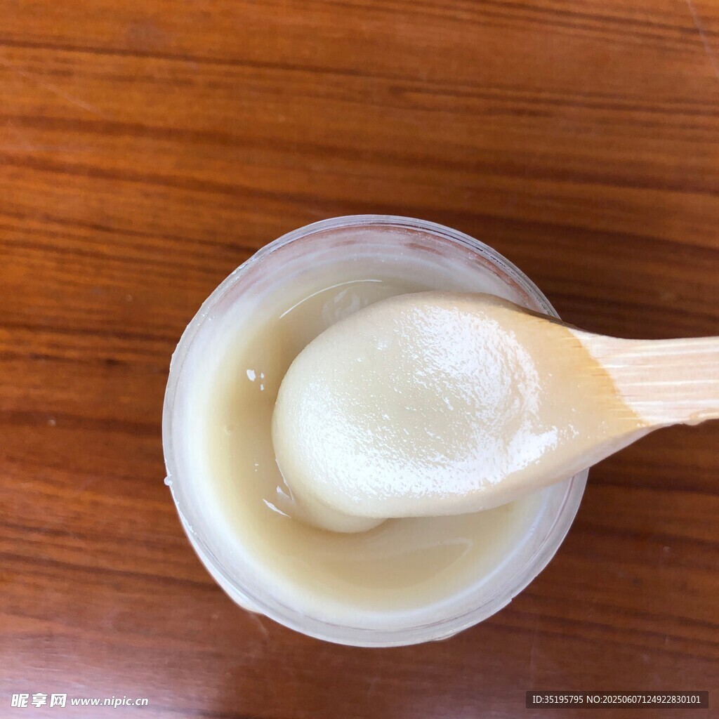 木勺舀取容器中的白色膏体