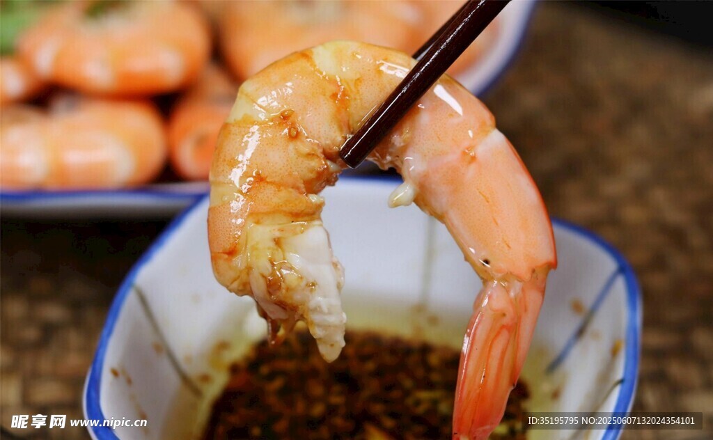 筷子夹虾蘸料特写