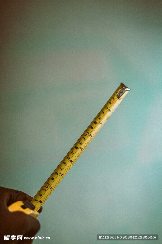 手持黄色卷尺特写