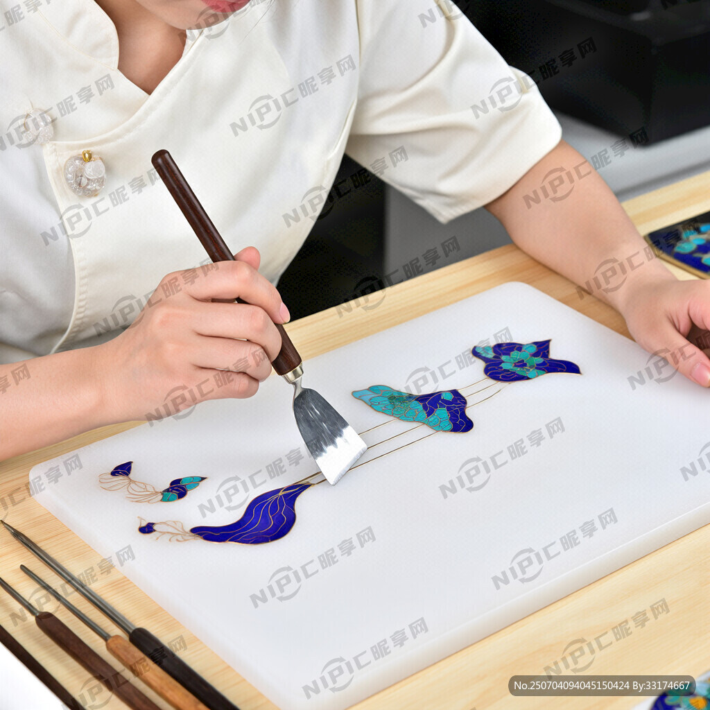 一个美女正在案台上面用点蓝铲刀