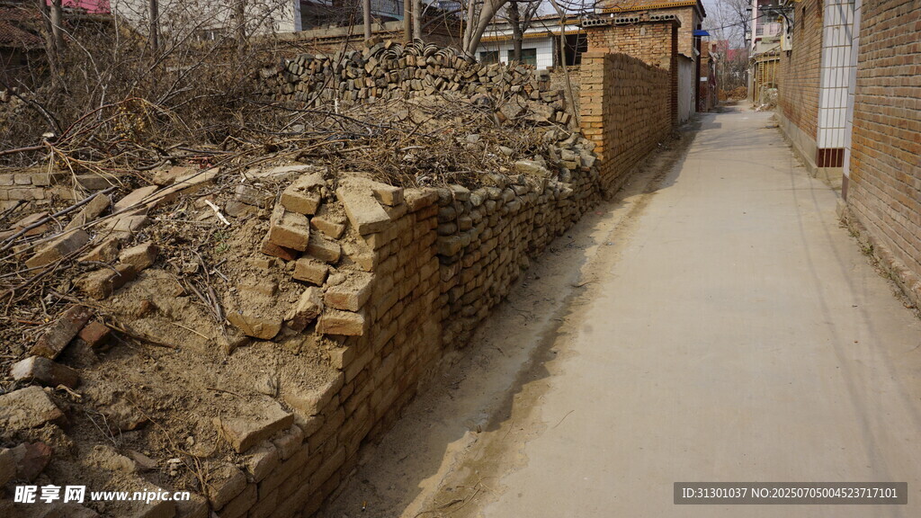 乡村小道旁的土堆与砖墙