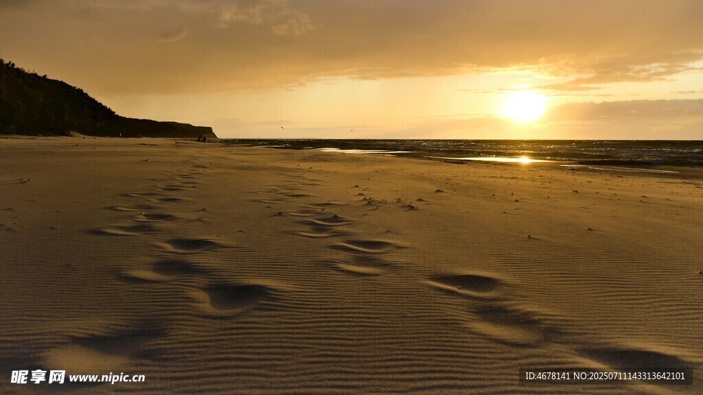 夕阳下沙滩上的串串脚印