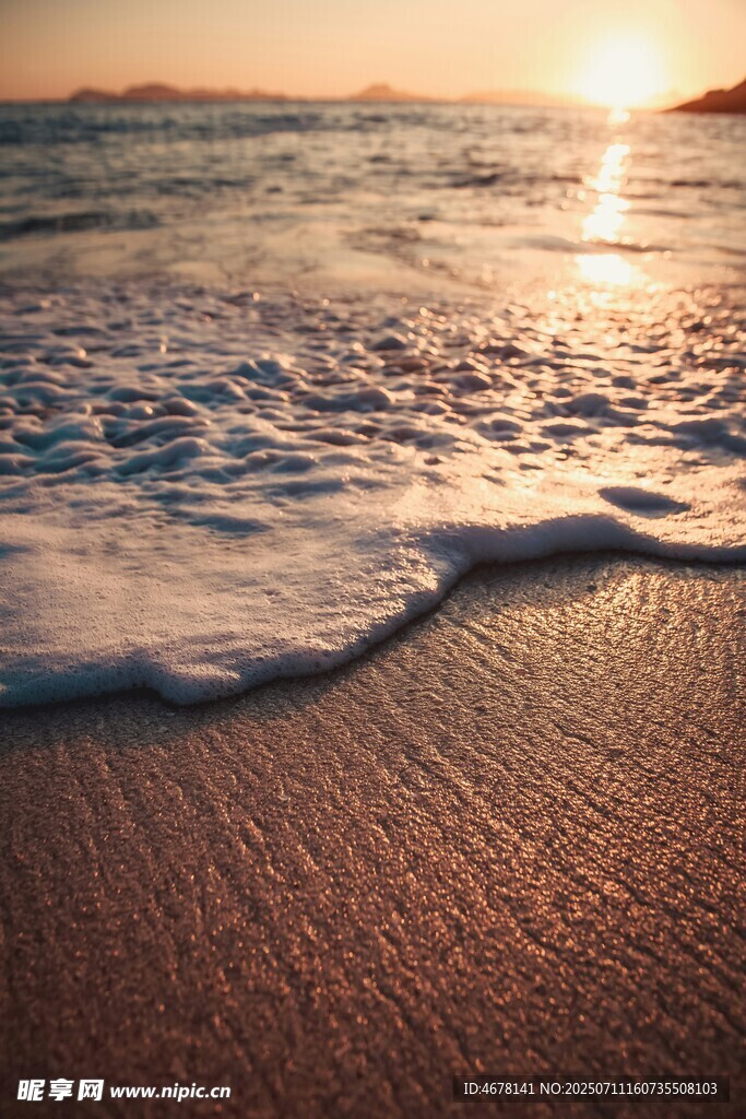 夕阳下的海浪轻拍沙滩