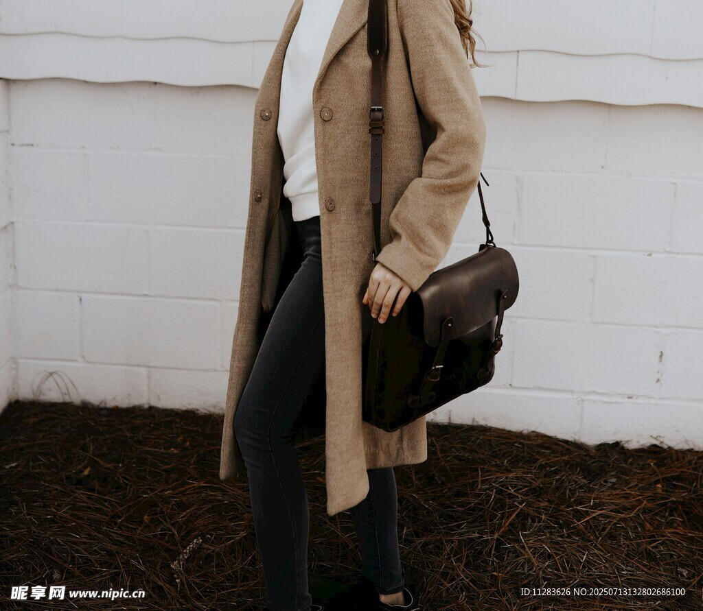 时尚女子身着长款风衣挎包