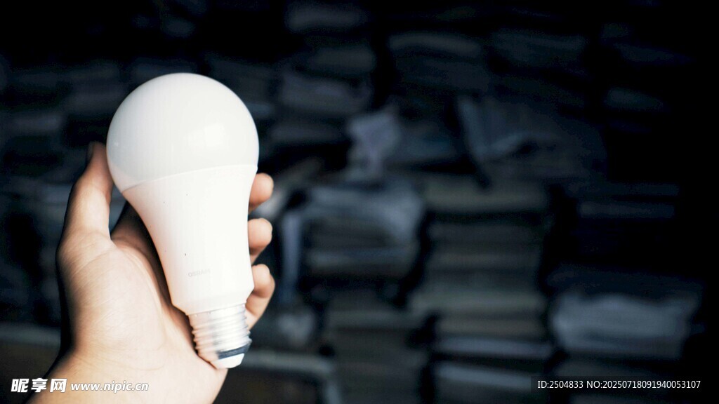 手托灯泡 背景是旧物