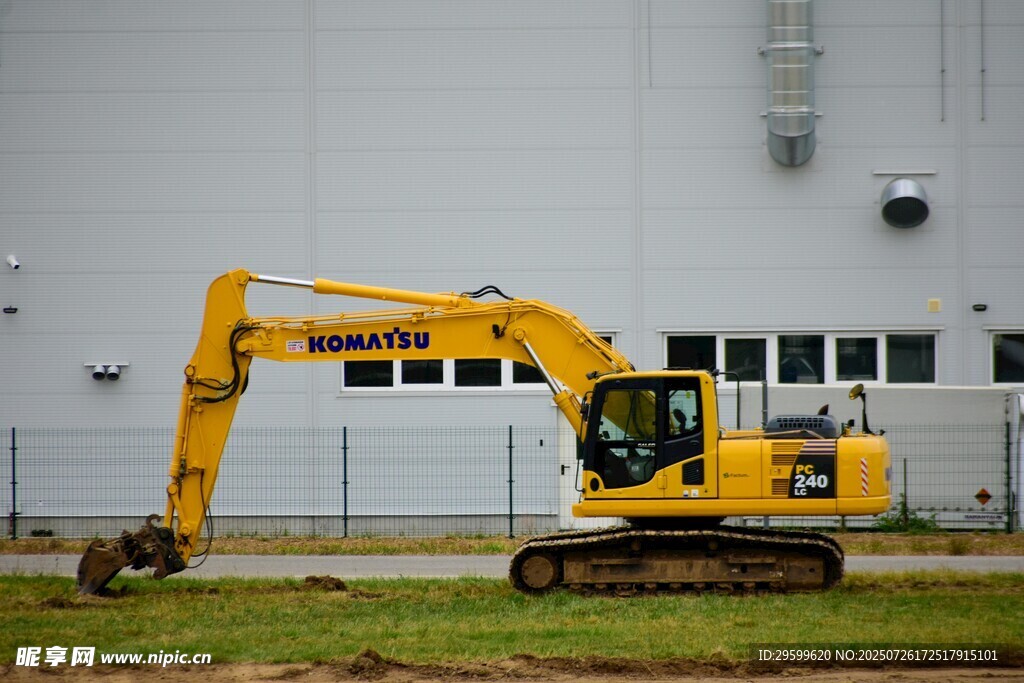 黄色挖掘机停在建筑旁