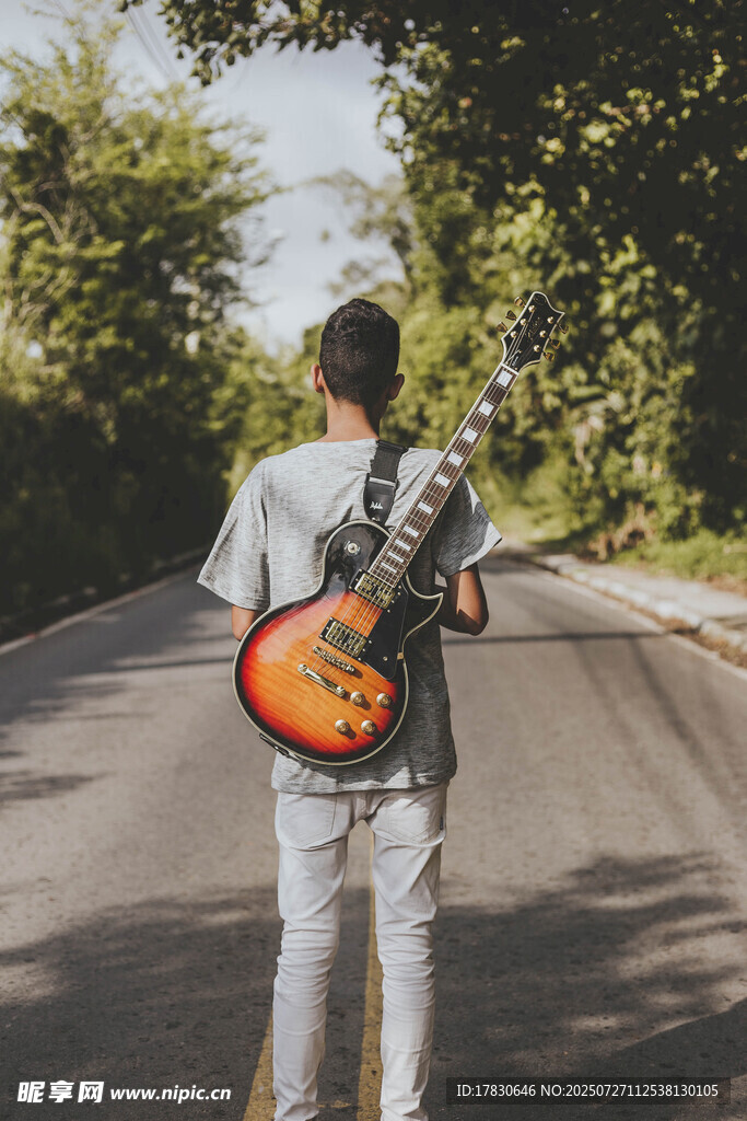 街头持吉他的背影男子