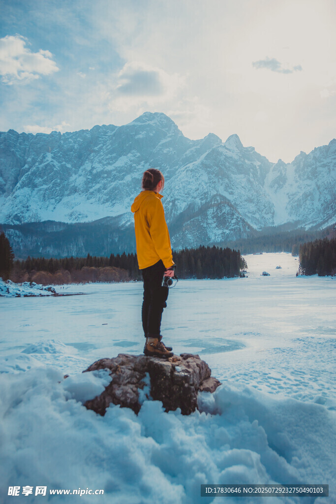 男子立于冰雪湖景赏远山