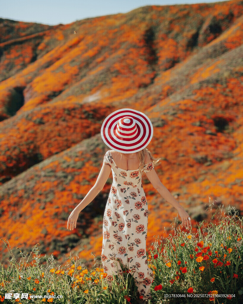 花海中戴独特帽子的女子