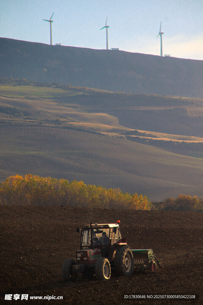 田野中的农机与远处风车