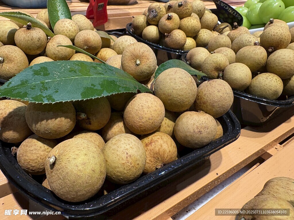 新鲜龙眼摆放在水果摊上