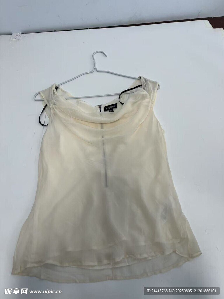 米白色无袖上衣挂于衣架
