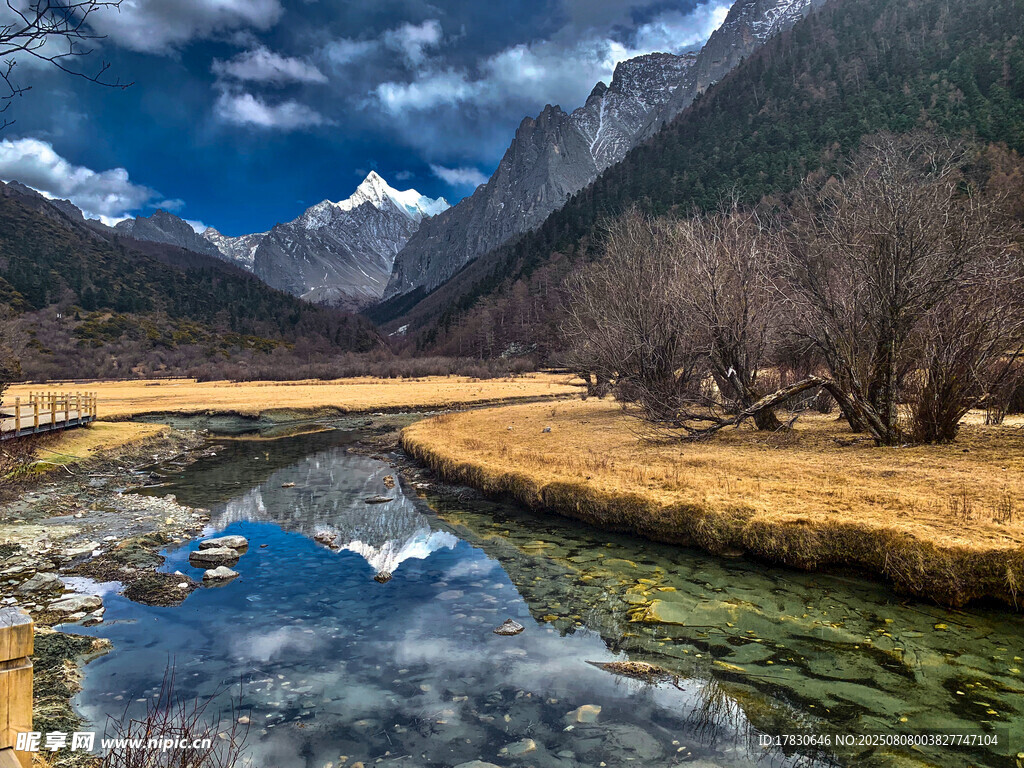 山间溪流旁的壮丽雪山景色
