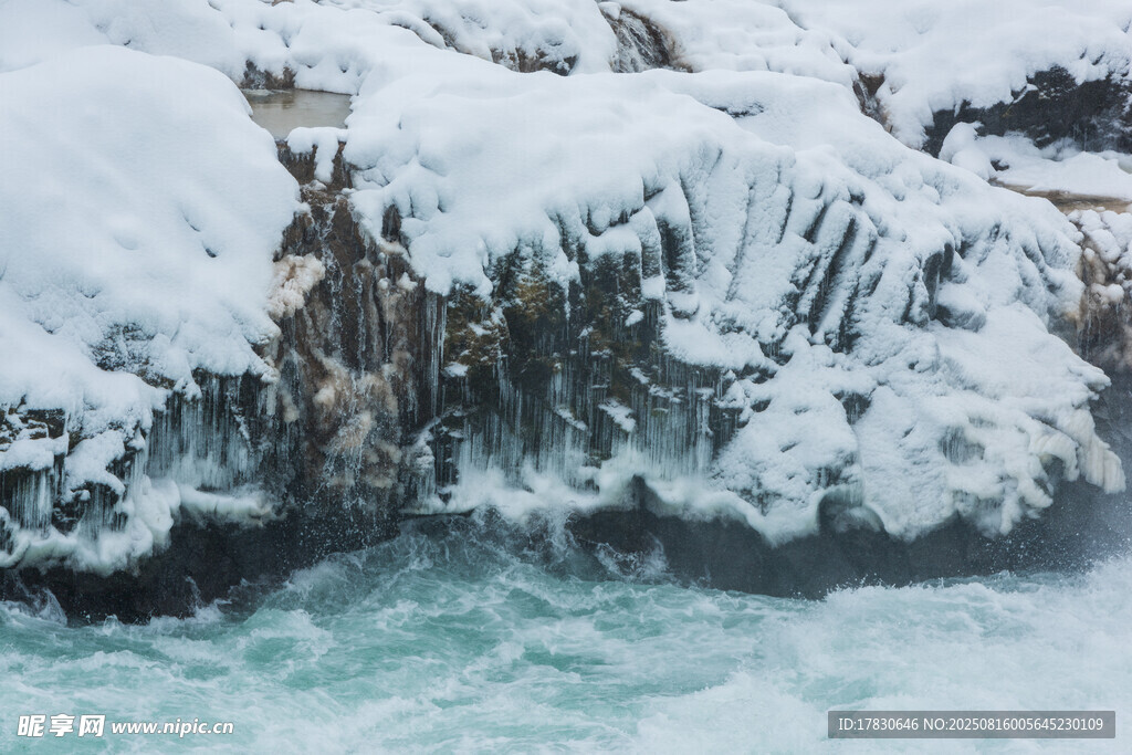 雪覆岩石旁的湍急流水