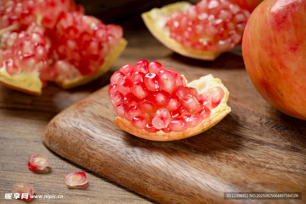 切开的新鲜红石榴摆于木桌