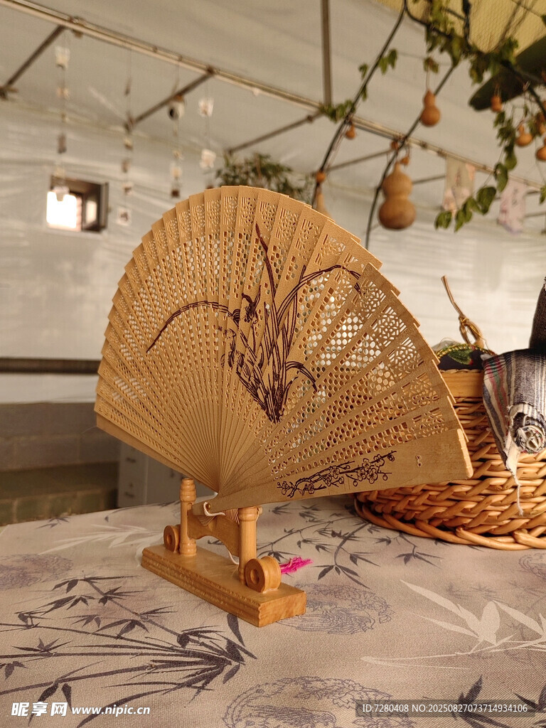 竹制折扇置于雅致桌布上
