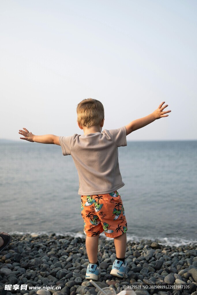 海边孩童舒展双臂迎海风