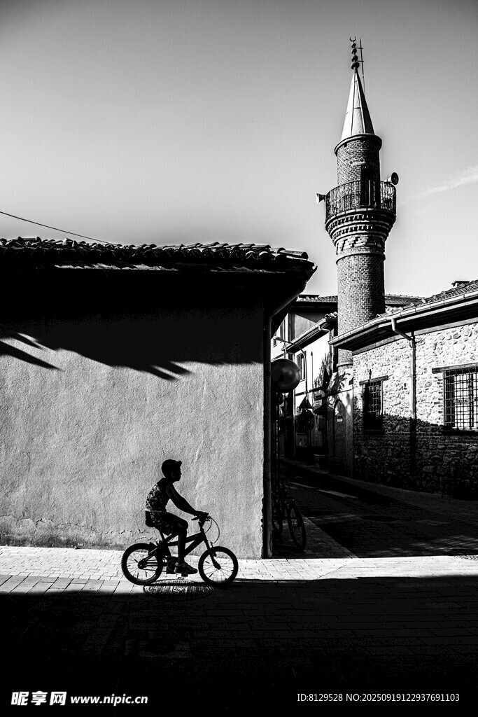 骑行者与远处尖顶建筑剪影