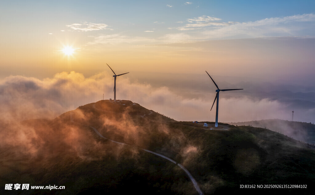 日出下的山间风力发电机组