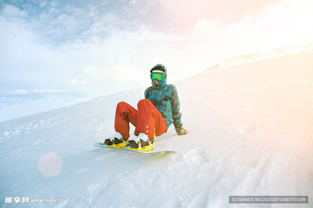 雪地中坐着的单板滑雪者