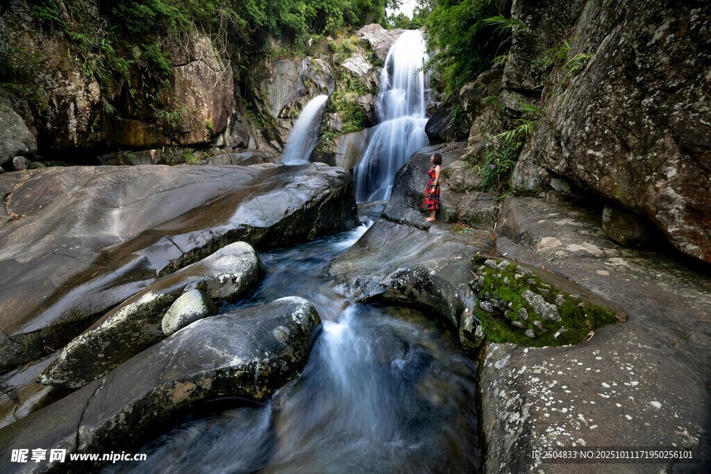 山间瀑布下的徒步者
