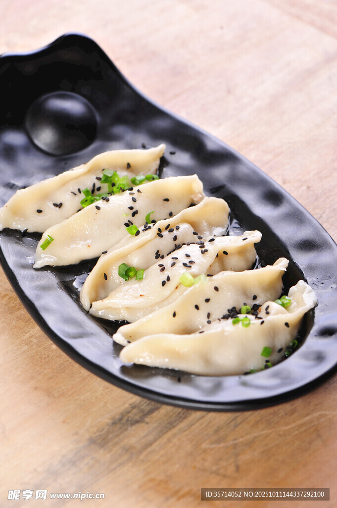 美味蒸饺摆于黑色盘中