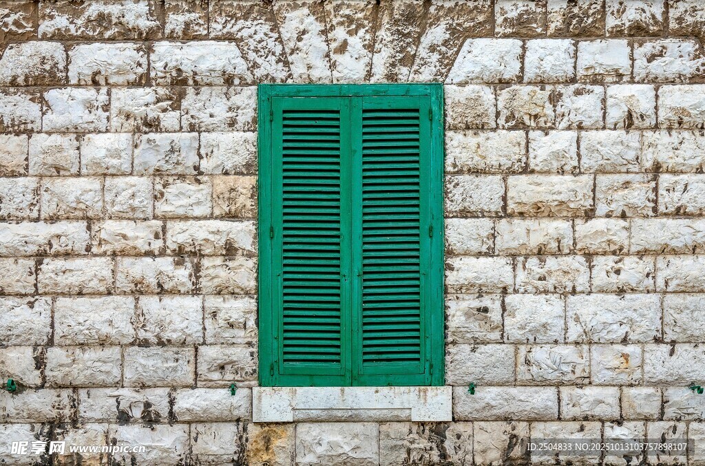 石墙上的绿色百叶窗