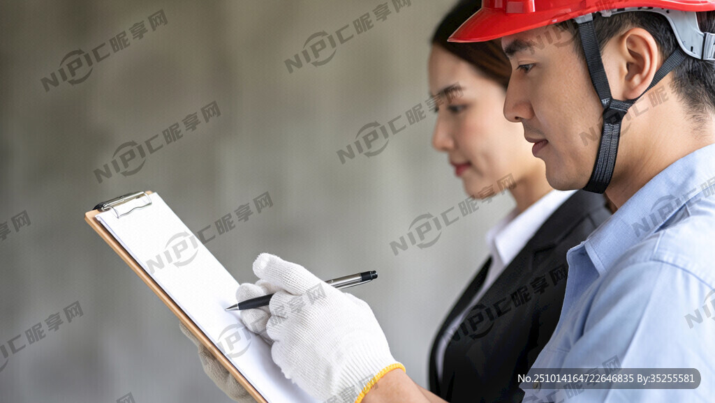 一个戴红色安全帽的工人侧面认真