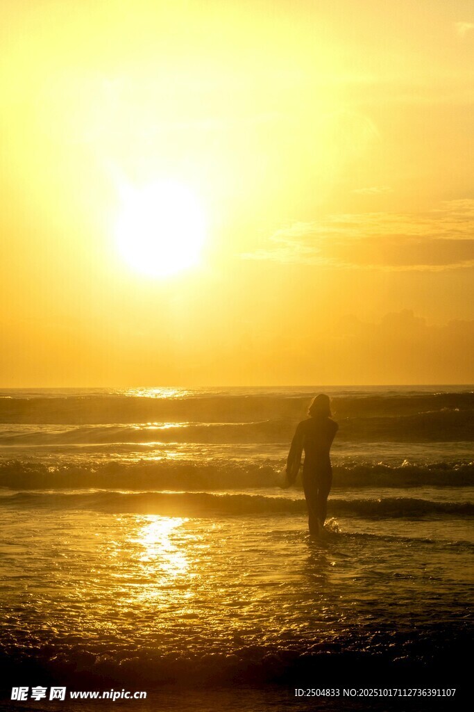 夕阳下的海边漫步身影