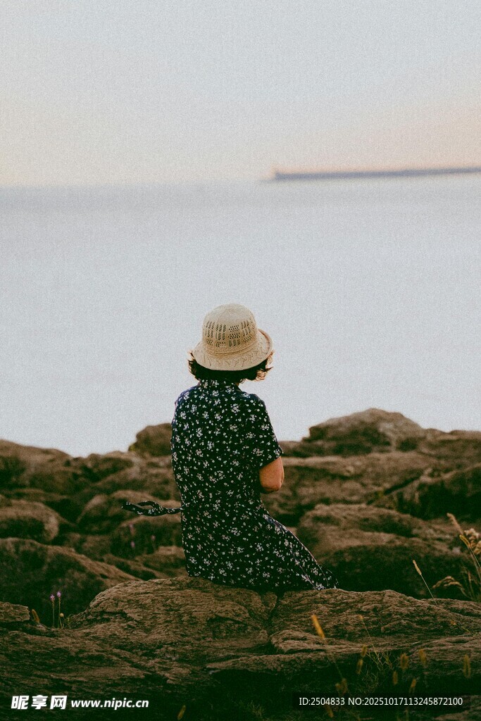 独坐海边的戴帽女子