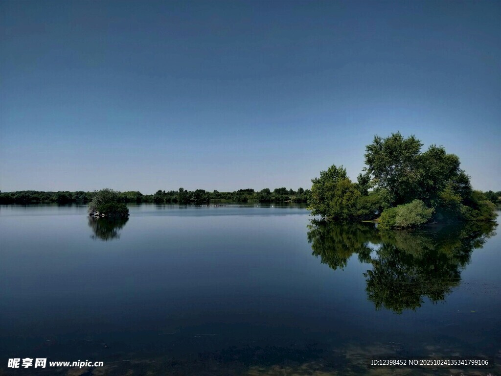 宁静湖面与岸边绿树倒影