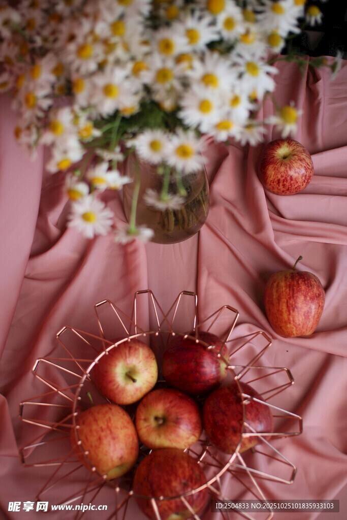 粉色布上的苹果与雏菊