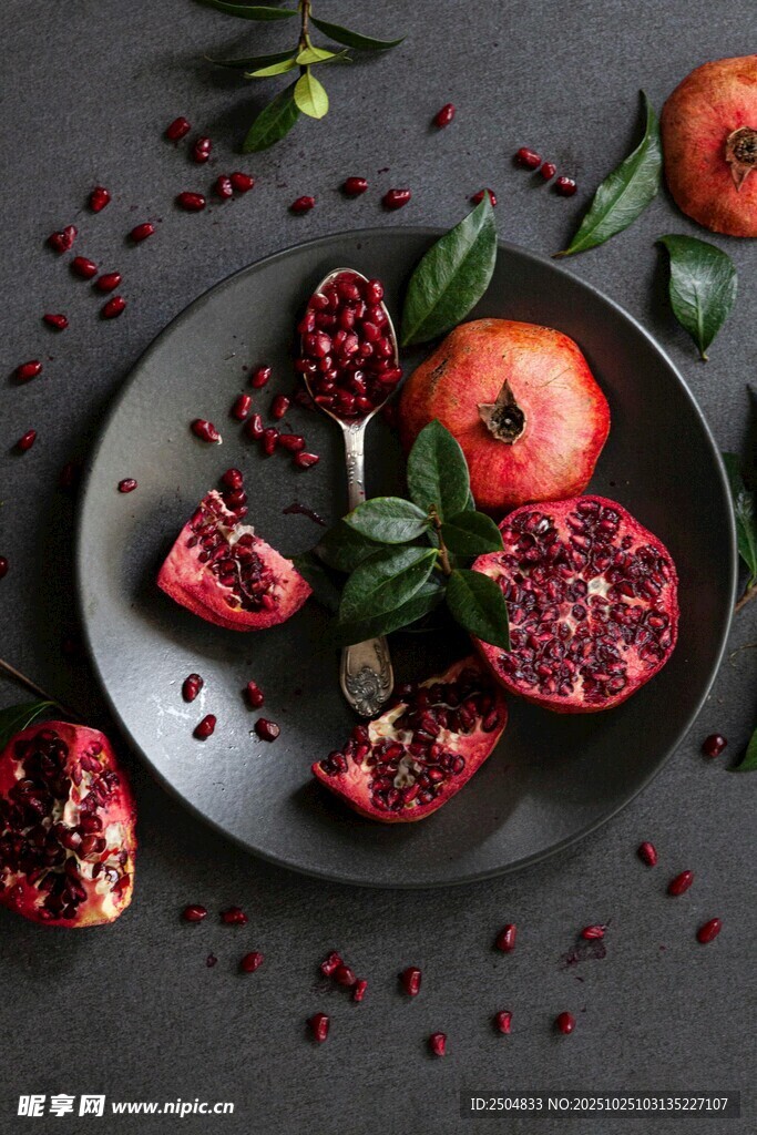 黑盘上的新鲜石榴及果粒