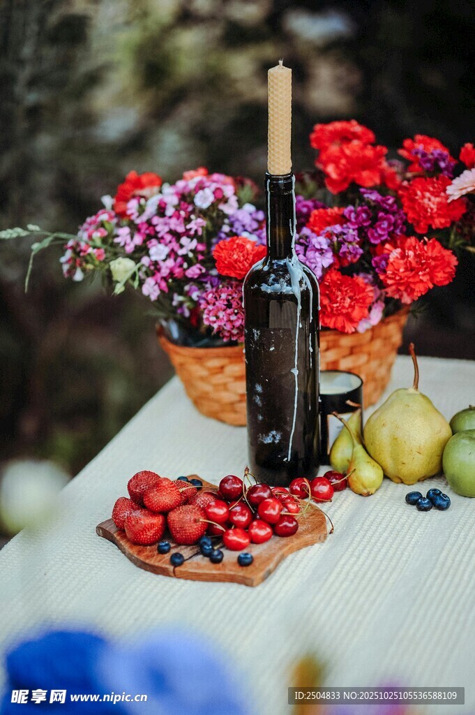 桌上美酒与缤纷水果花卉