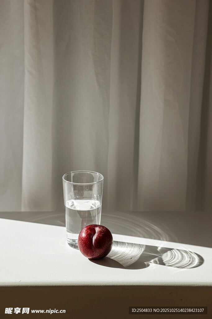 玻璃杯旁的红苹果与硬币
