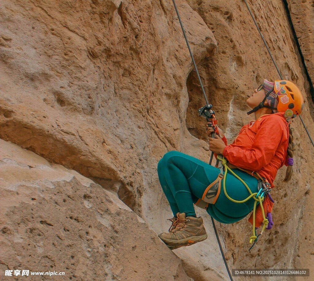 女子专注攀岩于陡峭岩壁