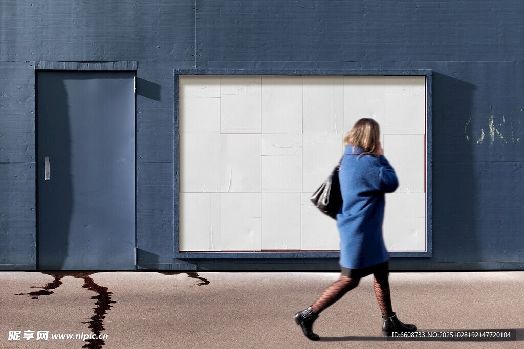 身着蓝衣女子行走于建筑旁