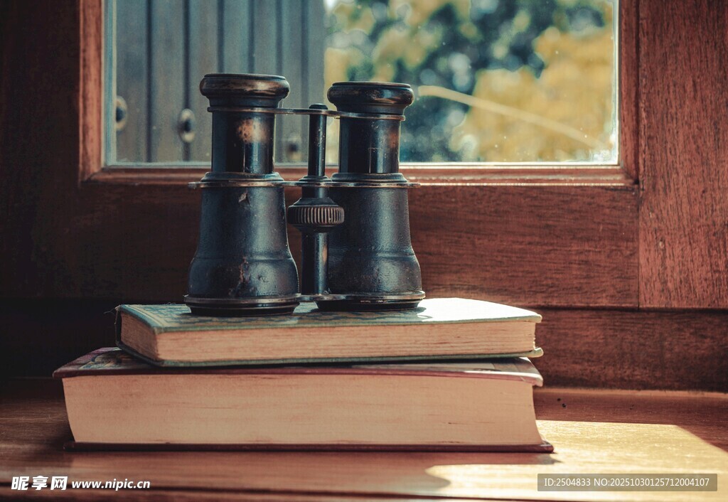 窗边望远镜置于书籍之上