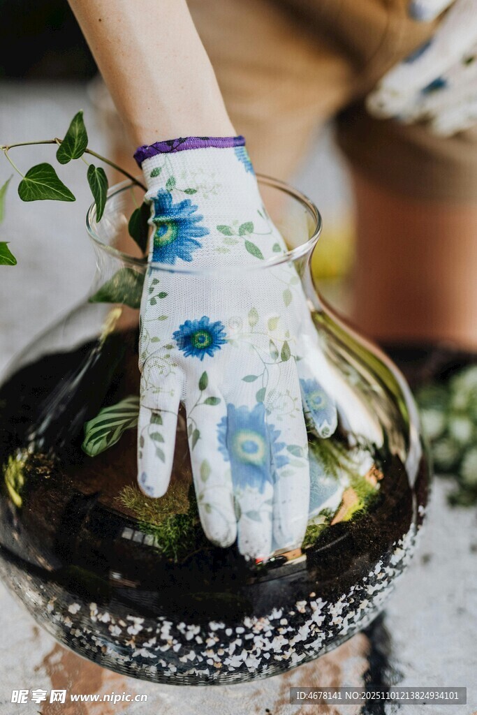 戴花手套的手在进行园艺
