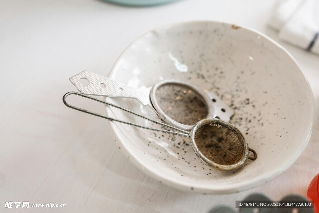 白色碗中放着金属茶滤